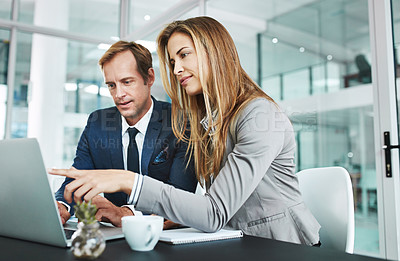 Buy stock photo Cropped shot of two businesspeople working together on a laptop