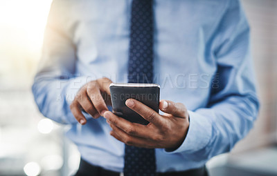 Buy stock photo Cropped shot of an unrecognizable businessman using his phone in the office