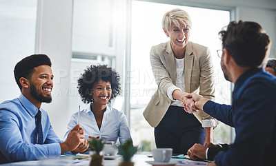 Buy stock photo Shot of two businesspeople shaking hands in a meeting