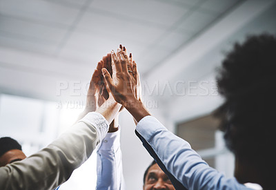Buy stock photo Cropped shot of a group of colleagues giving each other a high five in an office