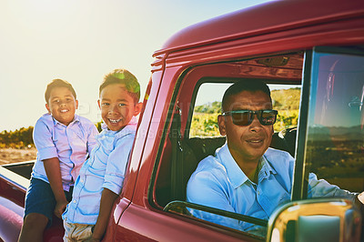 Buy stock photo Shot of a cheerful father wearing sunglasses while sitting inside of a red pickup truck with his two young sons