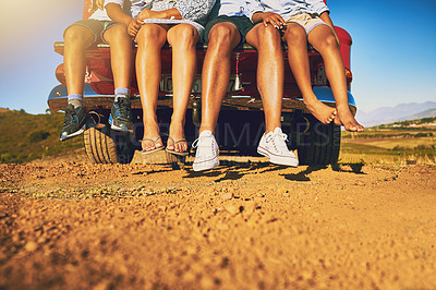Buy stock photo Low angle shot of a group of unrecognizable people's legs sitting on the back of a pickup truck outside