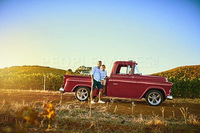 Buy stock photo Shot of a cheerful father and son standing together next to a red pickup truck while looking at the camera
