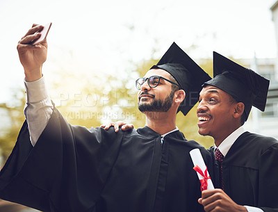 Buy stock photo Cropped shot of two students taking a selfie on graduation day