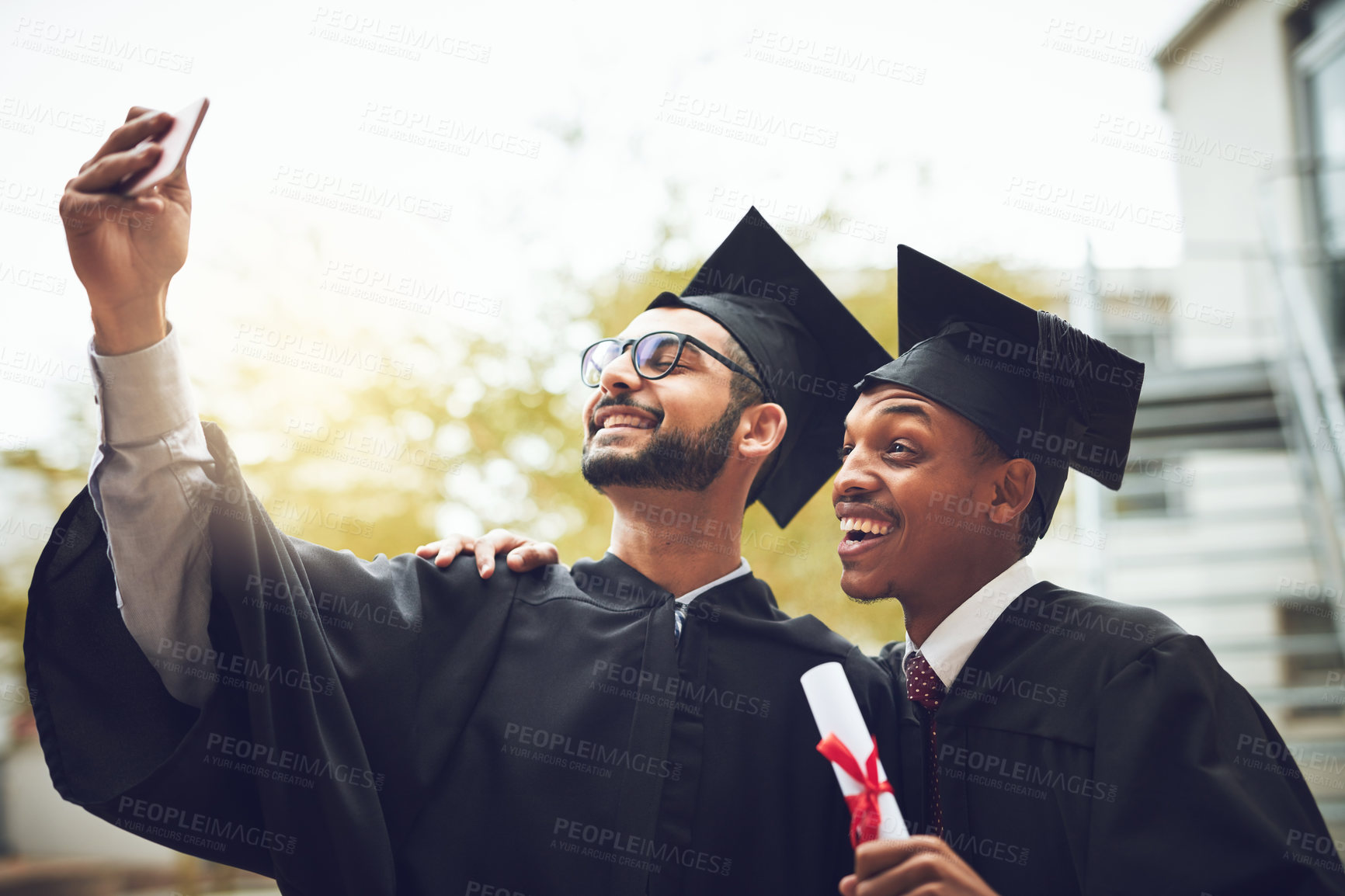 Buy stock photo Happy men, graduates and selfie with certificate for graduation memory, photography or celebration at university. Young, students or friends with smile for picture, academic achievement or degree