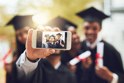 Buy stock photo Cropped shot of fellow students taking a selfie together on graduation day