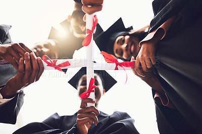 Buy stock photo Low angle shot of a group of fellow students standing together on graduation day