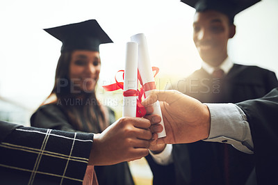 Buy stock photo Cropped shot of young graduates holding their diplomas together