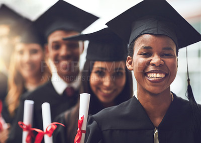 Buy stock photo Shot of a group of fellow students standing in a row on graduation day