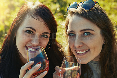 Buy stock photo Portrait of two young friends enjoying drinks together outdoors