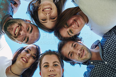 Buy stock photo Portrait of a group of friends standing with their heads together in a huddle outdoors