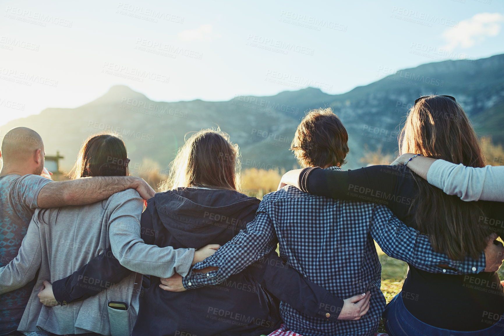 Buy stock photo Friendship, sunset and group in nature with hug for adventure, travel or weekend trip in countryside. Rear view, outdoor and people with embrace for vacation, support or bonding together in Australia