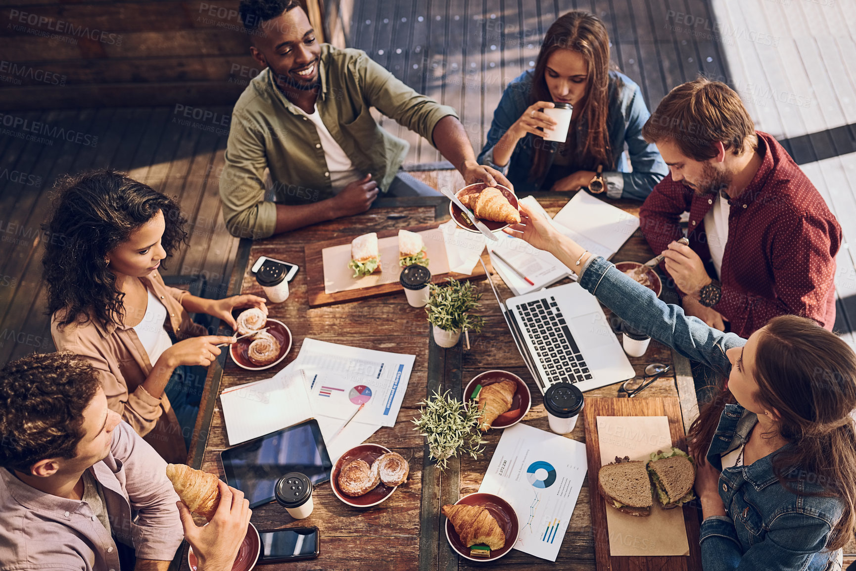 Buy stock photo Shot of a group of creative workers having a meeting over lunch in a cafe