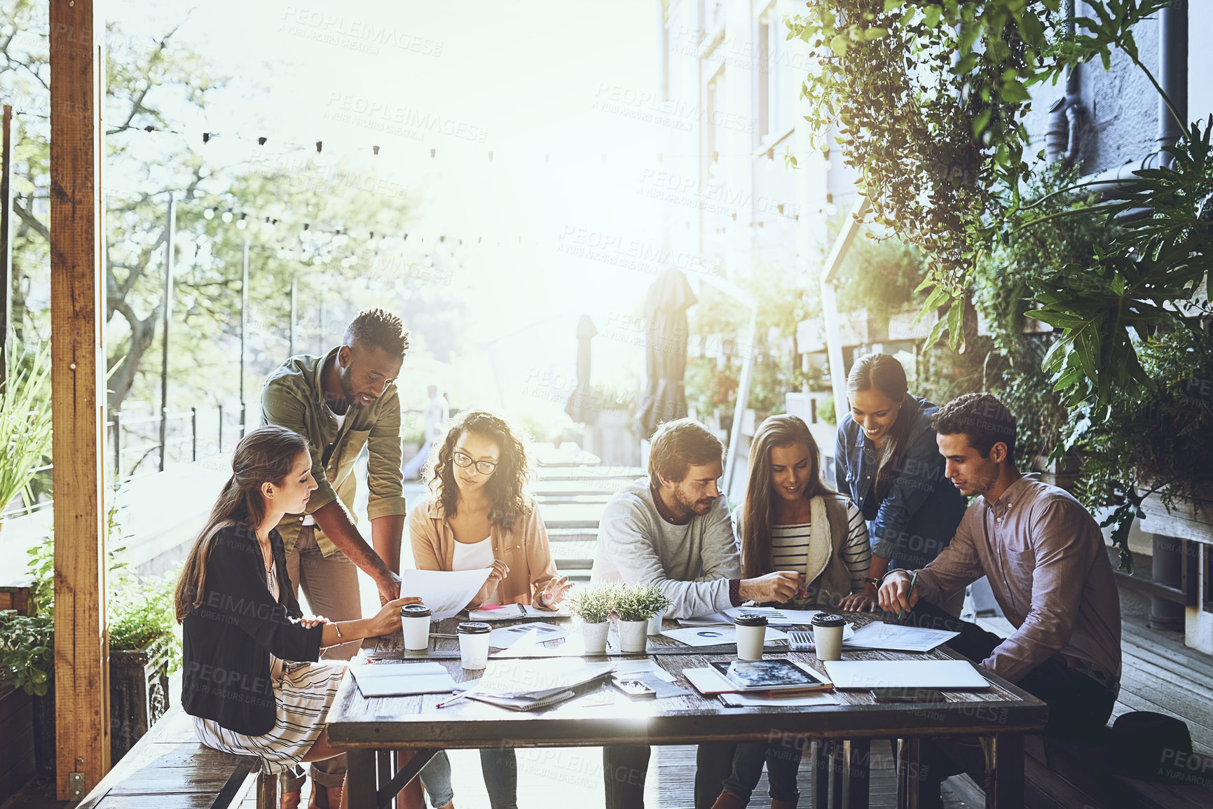Buy stock photo Shot of a group of colleagues having a meeting at a cafe