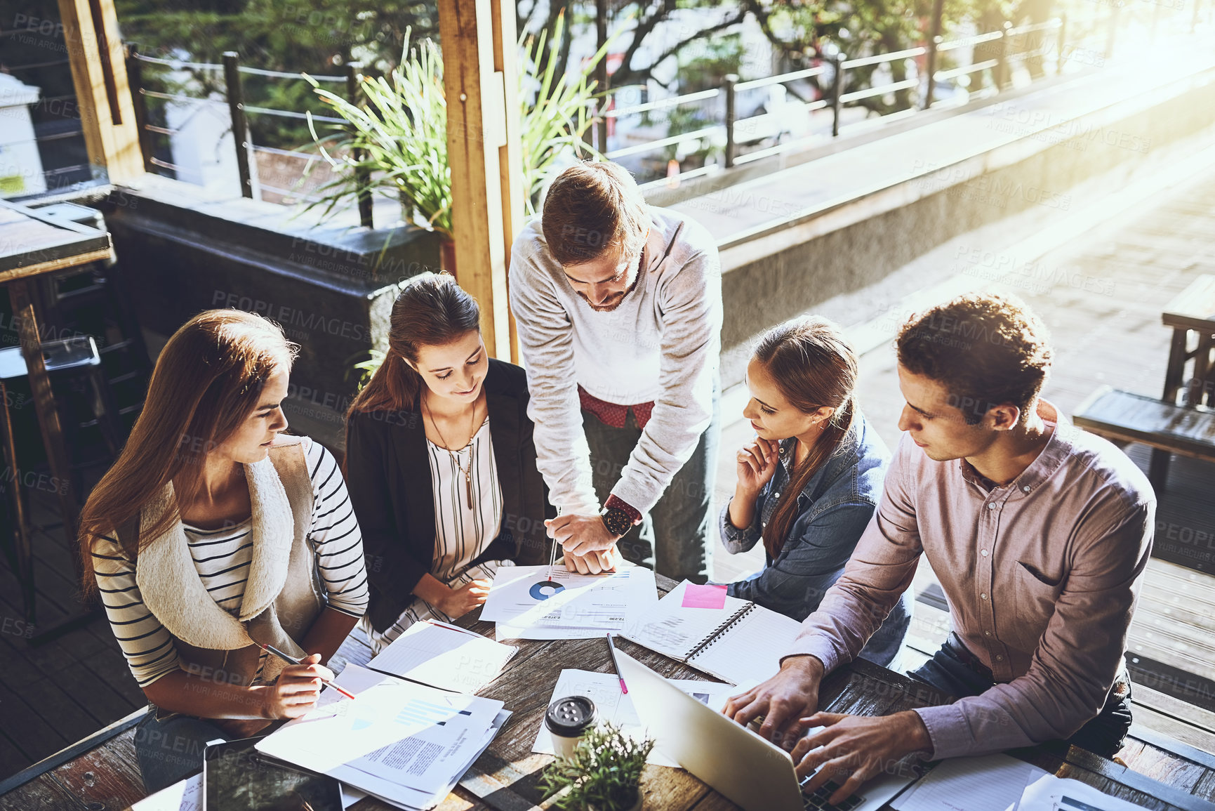 Buy stock photo Business, group and discussion in meeting, outdoor and ideas for project, graph and laptop in cafe. Planning, SEO and teamwork of people with stats, creative or typing of information and paperwork