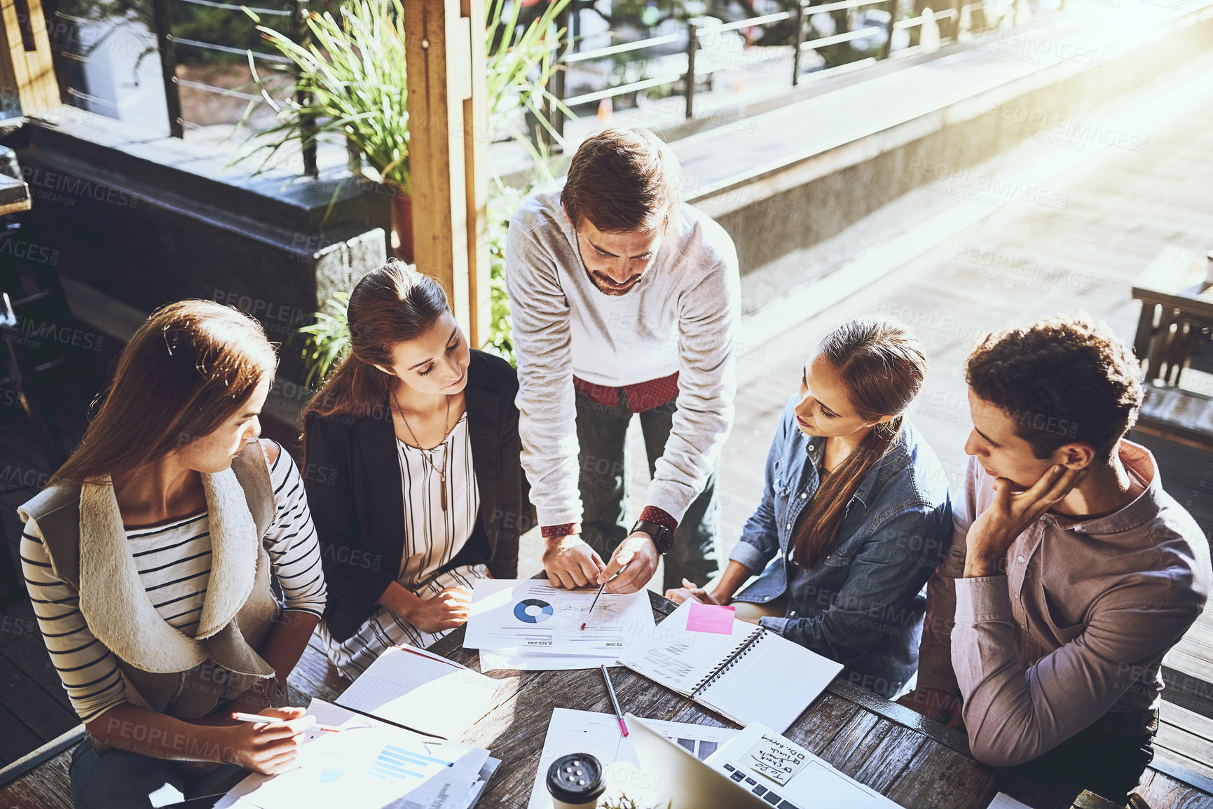 Buy stock photo Shot of a group of colleagues having a meeting at a cafe