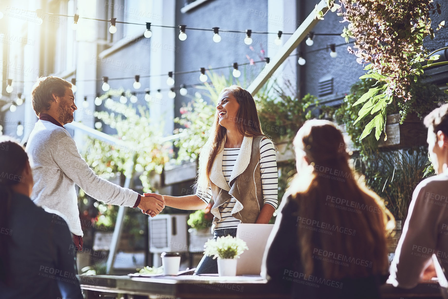 Buy stock photo Business people, happy and handshake in meeting at cafe for welcome, b2b networking and remote work outdoor. Group, employees and shaking hands for onboarding, partnership and laughing for agreement