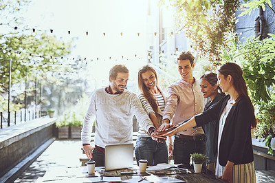 Buy stock photo Shot of a group of colleagues joining hands in agreement during a meeting at an outdoor cafe