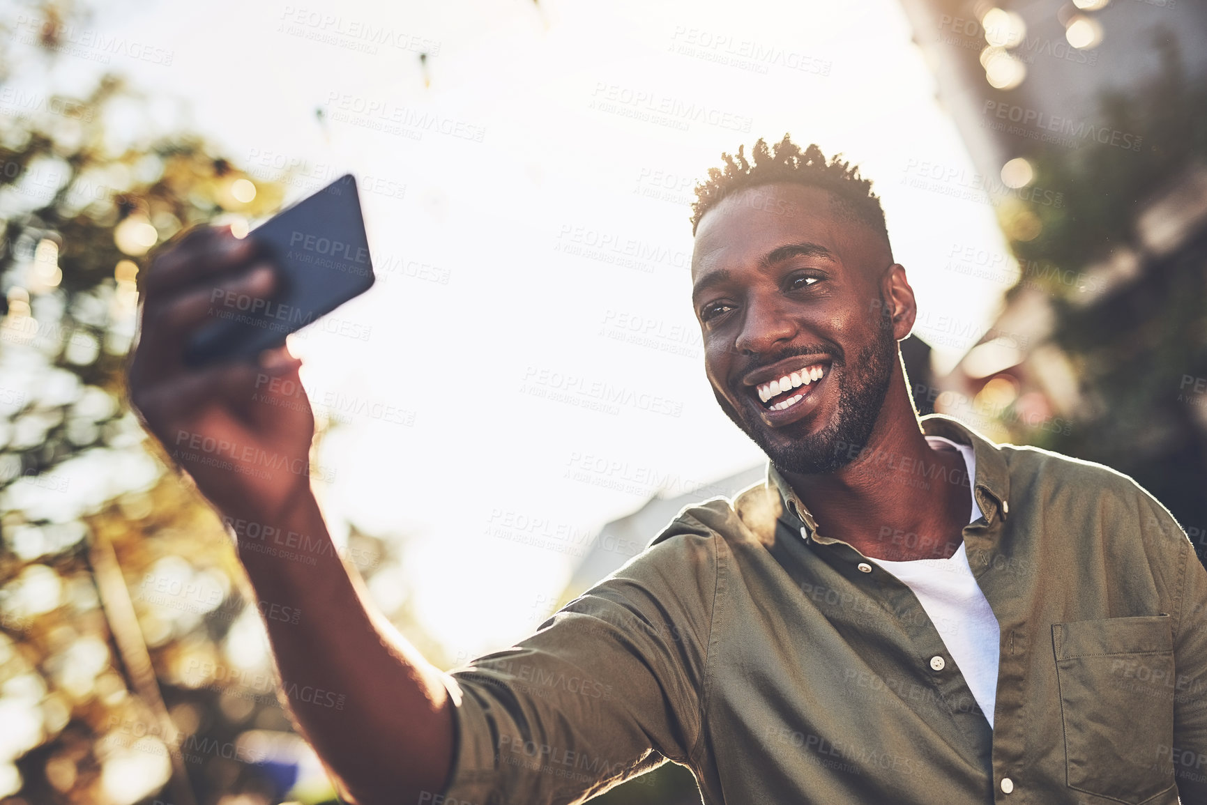 Buy stock photo Cropped shot of a handsome young man taking a selfie outside