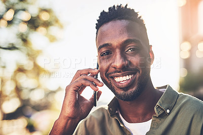 Buy stock photo Shot of a young man using his cellphone while standing outside