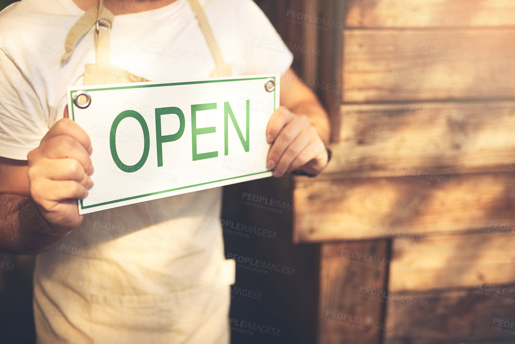 Buy stock photo Cropped shot of an unrecognizable business owner holding up a sign in the doorway of his coffee shop