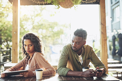 Buy stock photo Cropped shot of two young people using their wireless devices in a coffee shop