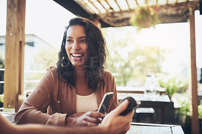 Buy stock photo Cropped shot of a female customer making a wireless payment in a coffee shop