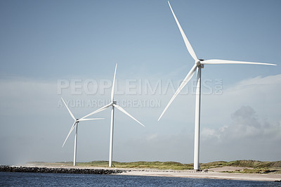 Buy stock photo Still life shot of wind turbines along the beachfront