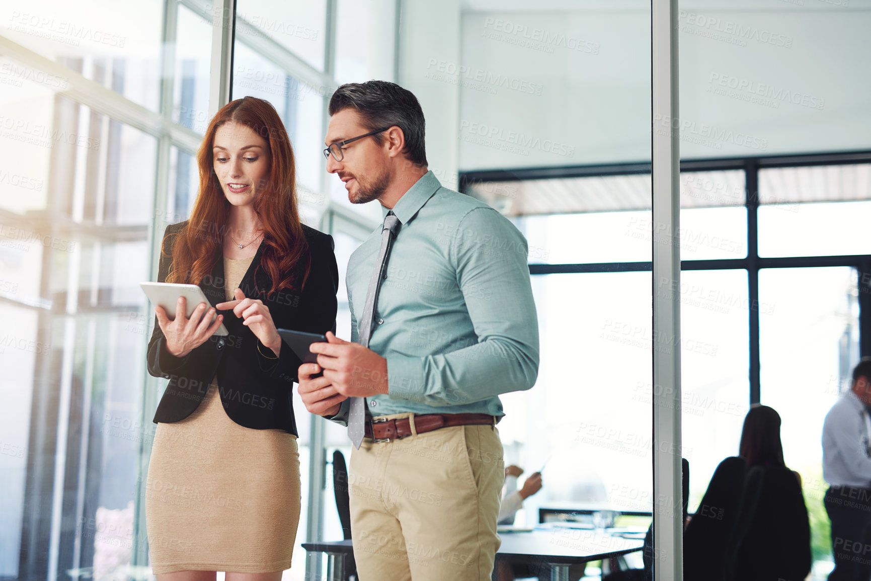 Buy stock photo Shot of colleagues using a tablet in a modern office