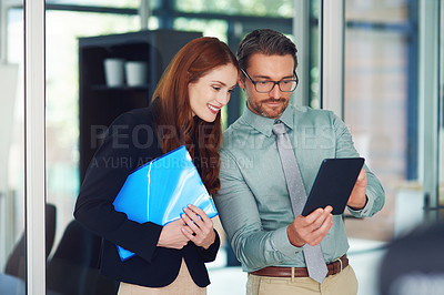 Buy stock photo Shot of colleagues using a tablet in a modern office