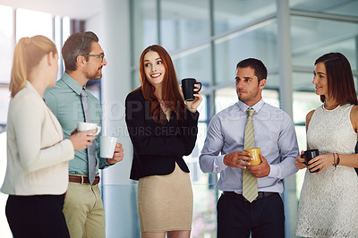 Buy stock photo Shot of colleagues having a discussion and drinking coffee in a modern office