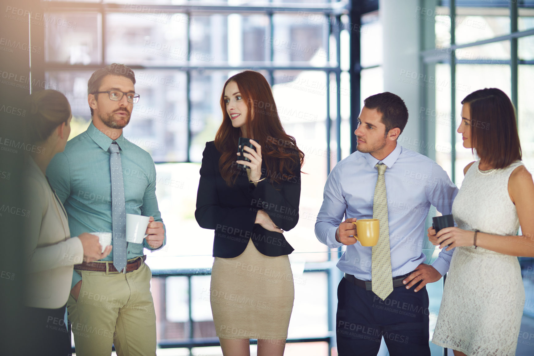 Buy stock photo Shot of colleagues having a discussion and drinking coffee in a modern office