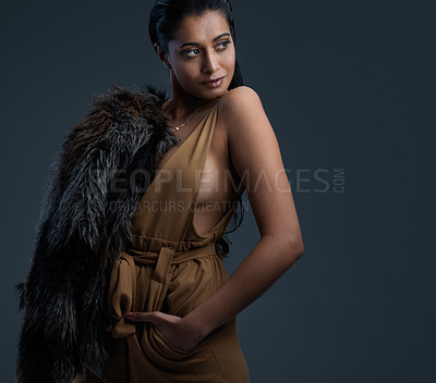 Buy stock photo Studio shot of a beautiful young woman posing against a dark background