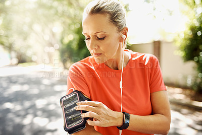 Buy stock photo Mature, active and fit woman listening to music while running outside. Older person motivated for her positive, and athletic lifestyle. Female training for sport event or summer vacation body.

