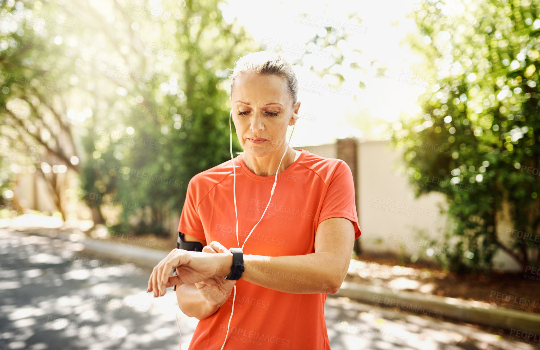 Buy stock photo Fitness, running and watch with mature woman in street of neighborhood for cardio or physical activity. Break, exercise and time with athlete or runner outdoor for training or workout in summer
