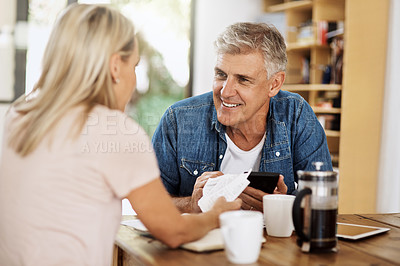 Buy stock photo Couple paying bills with phone online, working on finance budget and banking on smartphone in the kitchen at home. Happy man and womanready for retirement, planning pension fund and drinking coffee