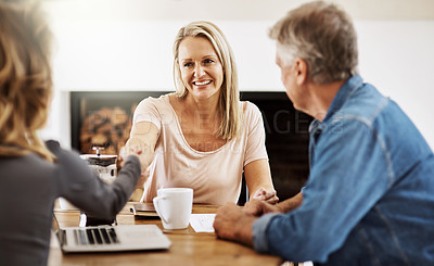 Buy stock photo Financial advisor shaking hands with a female client after helping with budget, making a deal and planning with documents at home. Husband and wife paying for insurance and meeting with a consultant