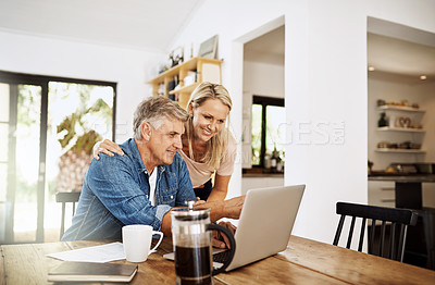 Buy stock photo Couple with laptop planning finance, banking and checking retirement budget while becoming debt free at home. Smiling, happy and cheerful mature man showing woman an approved bank loan on technology