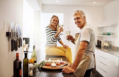 Buy stock photo Shot of a happy mature couple keeping each other company in the kitchen