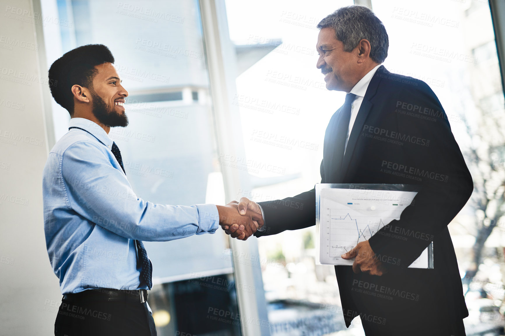 Buy stock photo Shot of two businessmen shaking hands in an office