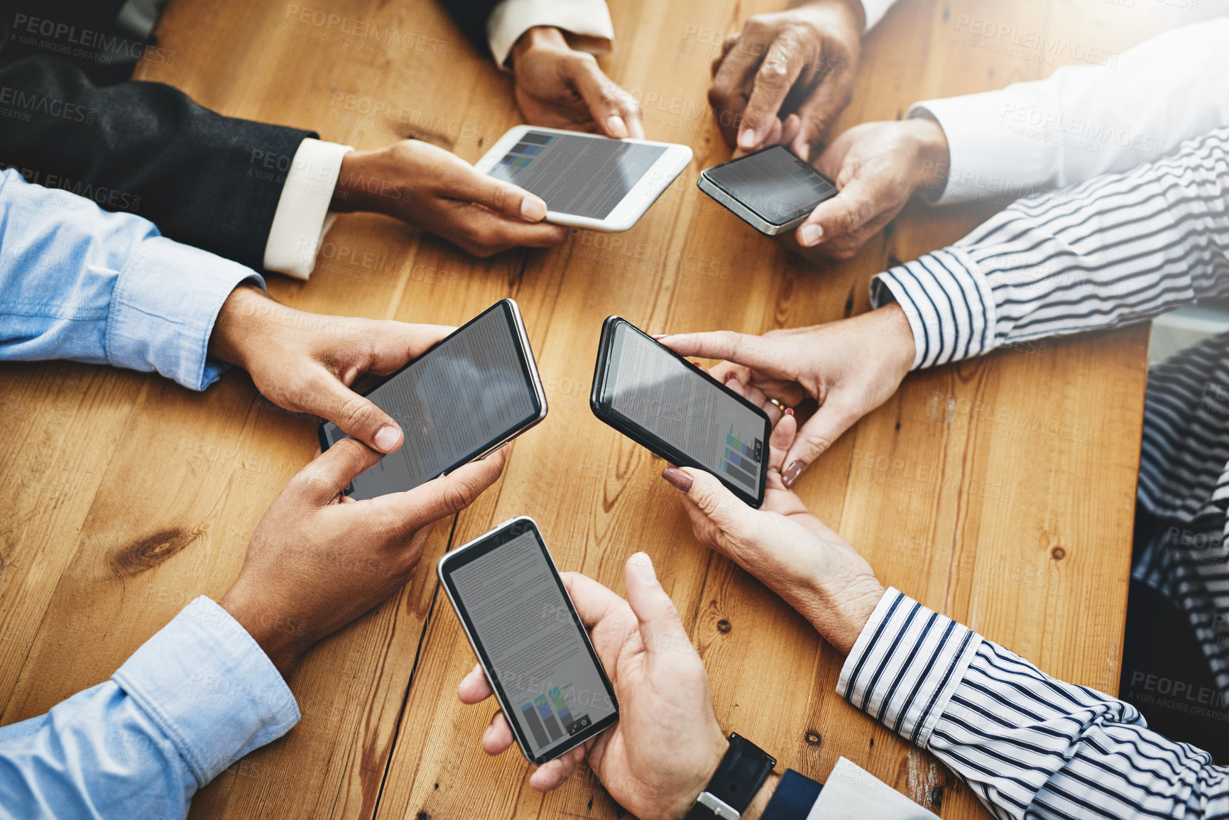 Buy stock photo Shot of a group of unrecognisable businesspeople using their cellphones in synchronicity