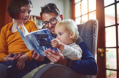 Buy stock photo Shot of father reading a book with his little son and daughter at home