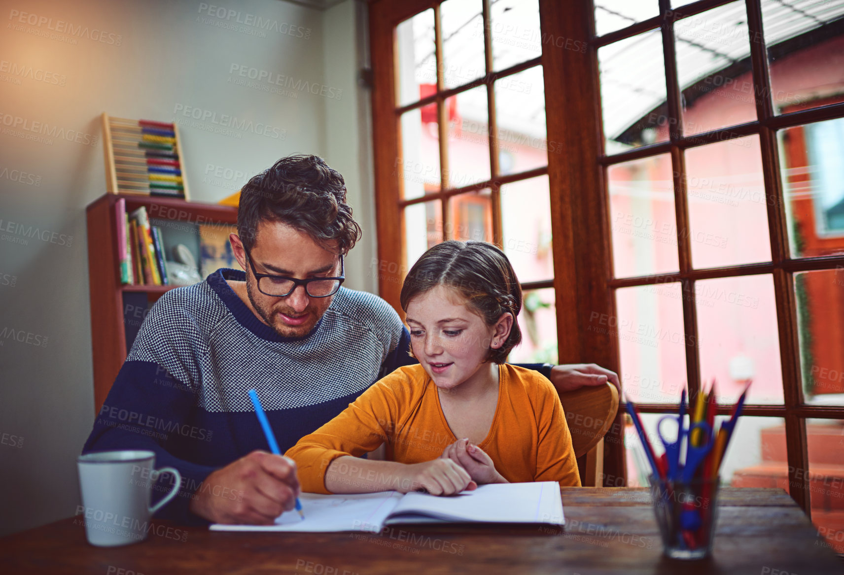 Buy stock photo Shot of a father helping his little daughter with her homework