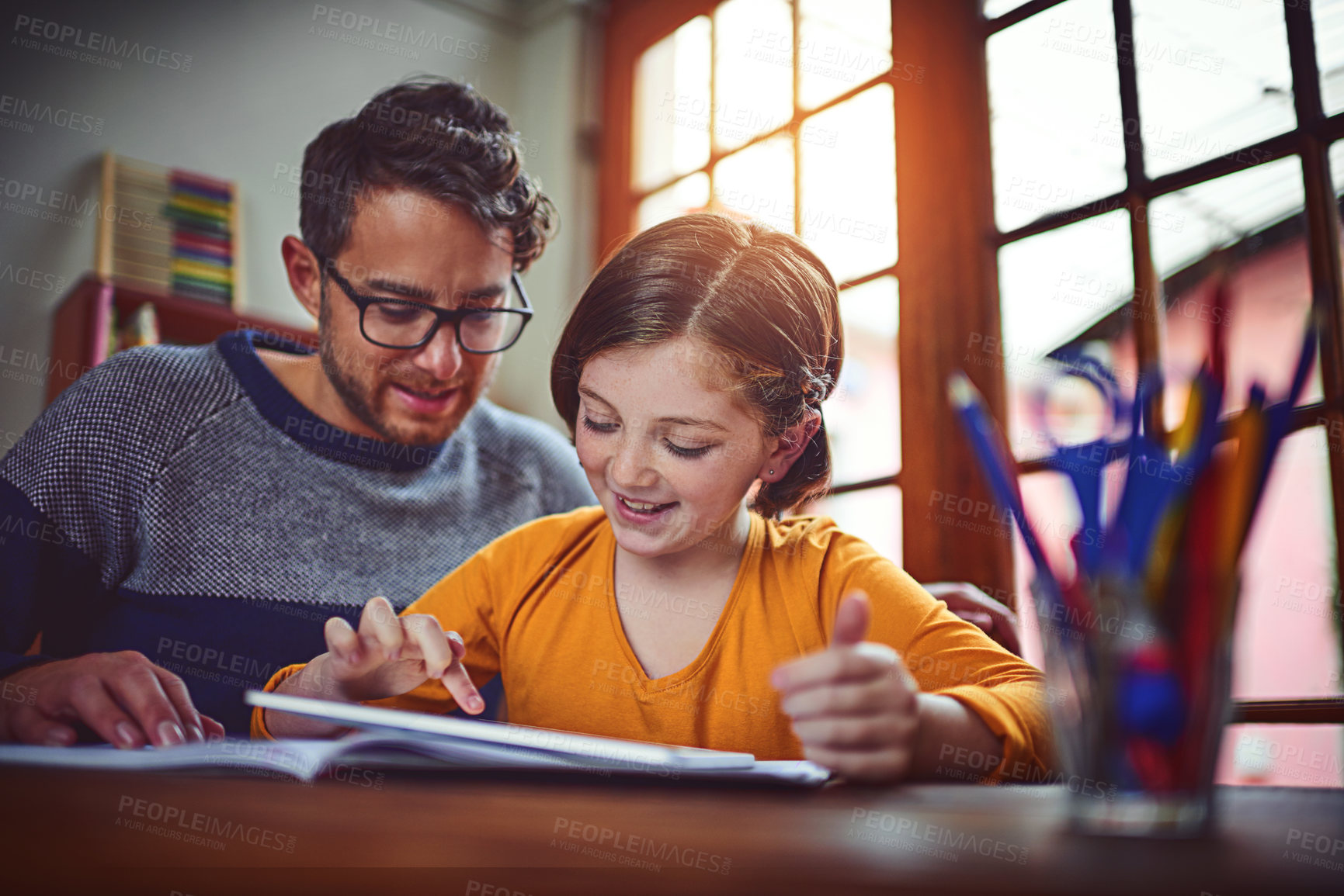 Buy stock photo Shot of a father helping his little daughter with her homework on a digital tablet