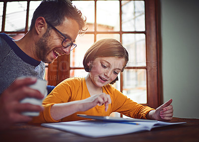 Buy stock photo Shot of a father helping his little daughter with her homework on a digital tablet