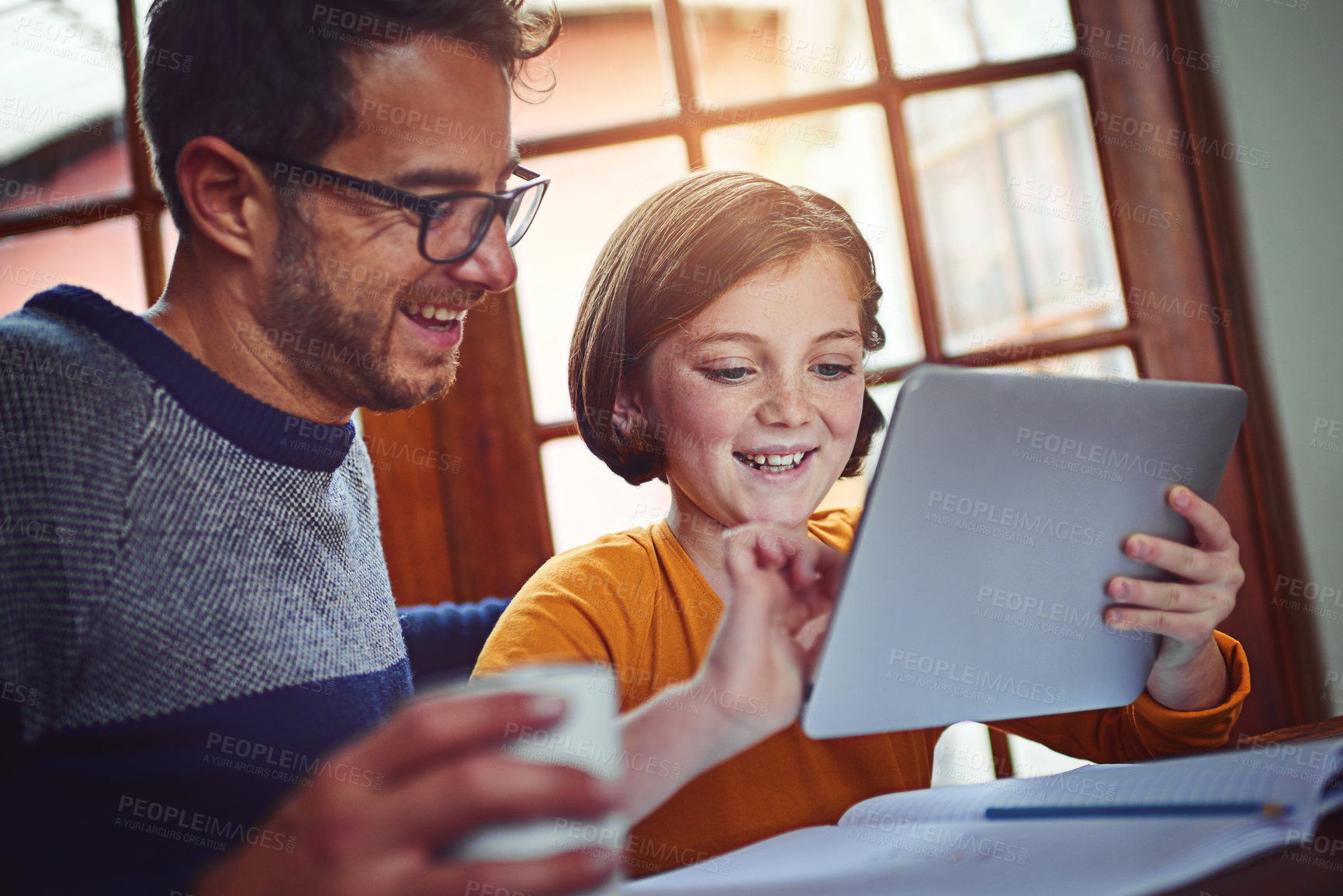 Buy stock photo Shot of a father helping his little daughter with her homework on a digital tablet