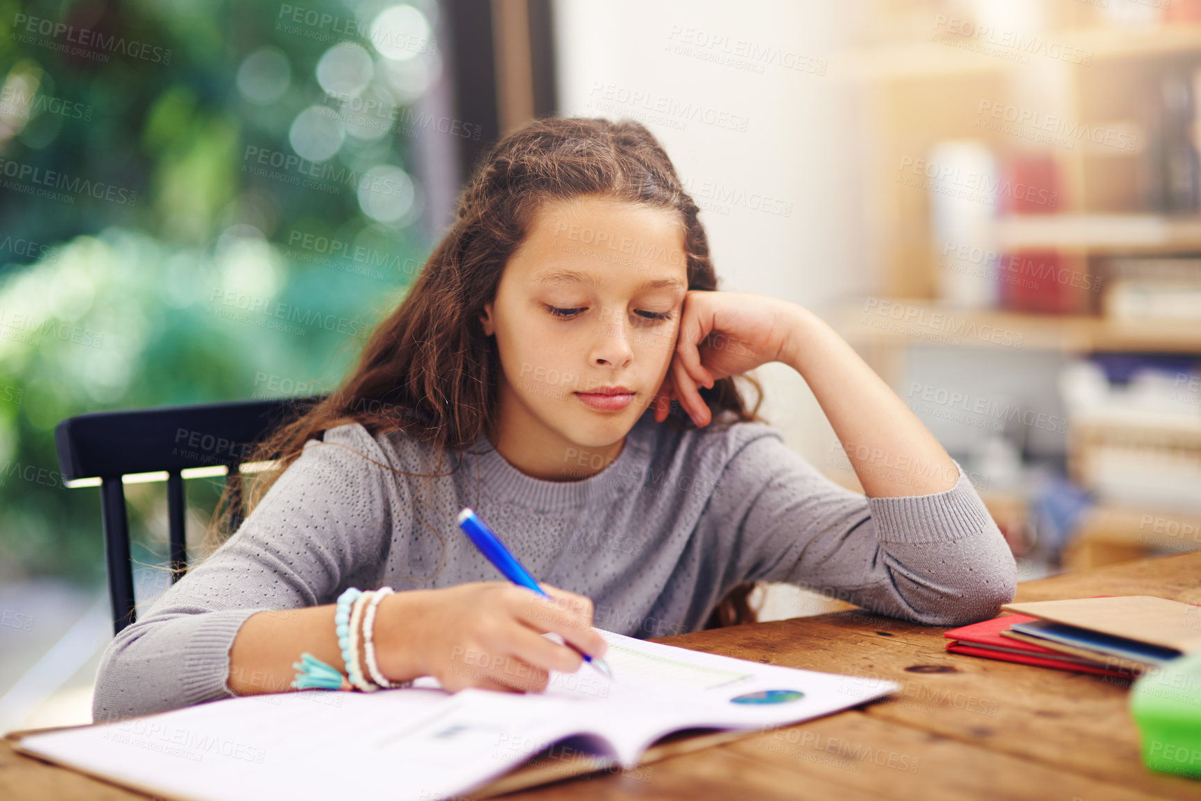 Buy stock photo Cropped shot of a young girl doing homework inside