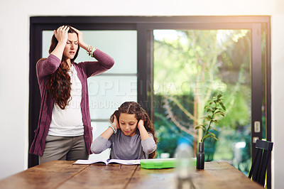 Buy stock photo Cropped shot of a young girl doing homework with her mother inside