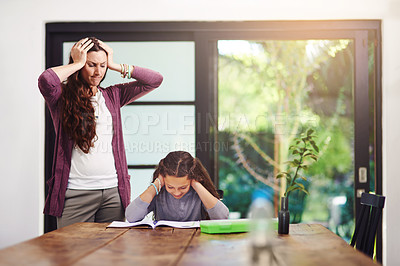 Buy stock photo Cropped shot of a young girl doing homework with her mother inside