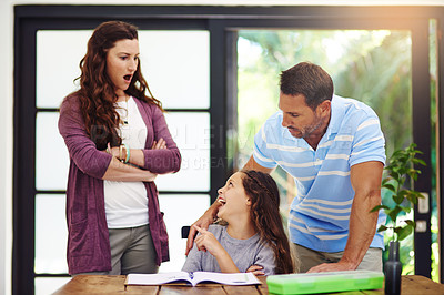 Buy stock photo Cropped shot of a young girl doing homework with her parents inside